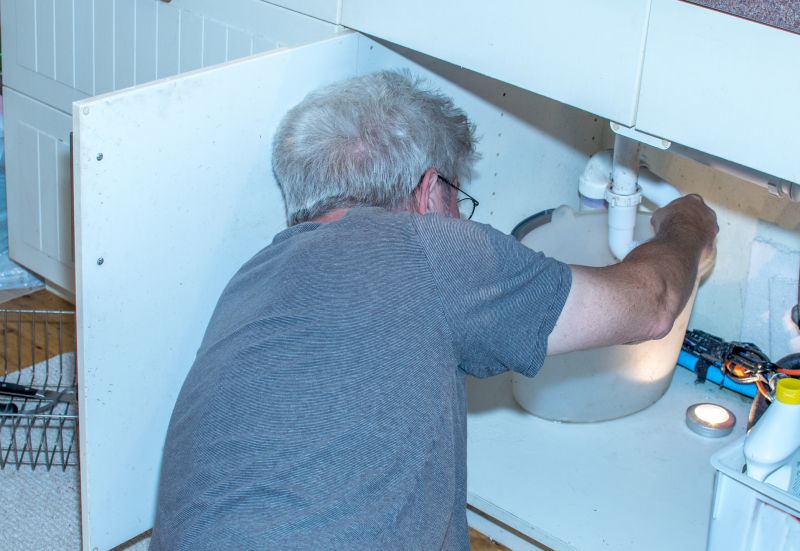 Plumber Working Under Sink
